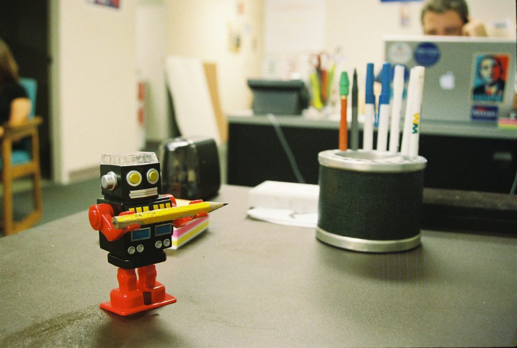 A pencil sharpener in a form of a robot on a desk