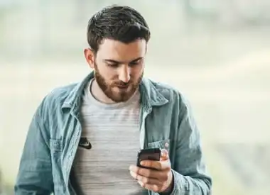 An image showing a man on his phone