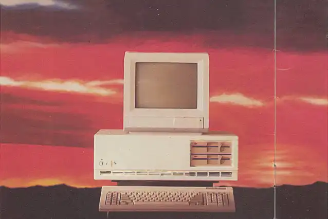 An image showing an old computer against a background with a sunset