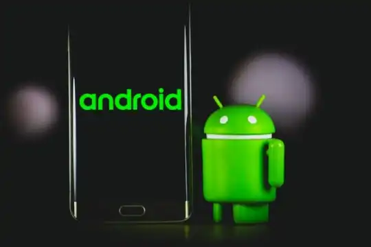 Android's mascot next to a smartphone displaying Android's logo